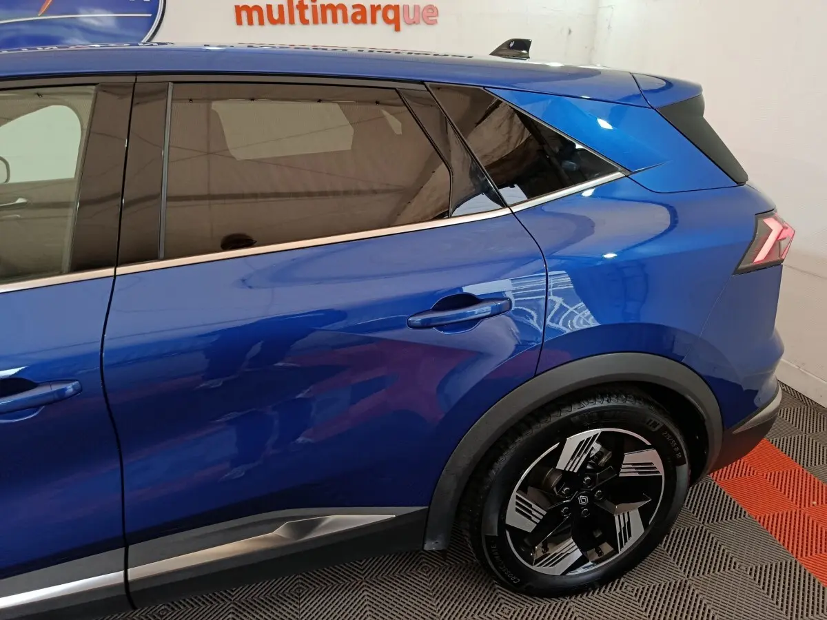 Vue latérale droite du Renault SYMBIOZ bleu 2025, mettant en valeur la porte arrière et la roue arrière au design moderne.