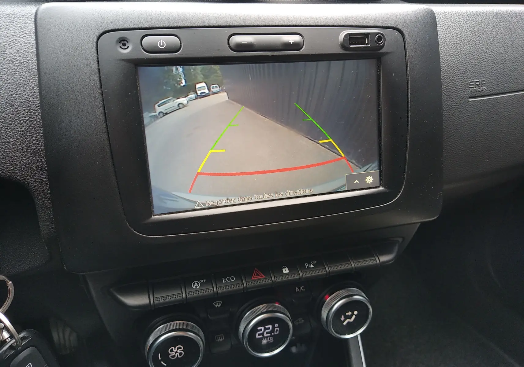 Écran central du Dacia Duster 2020 montrant la caméra de recul avec guidage coloré, tableau de bord noir.