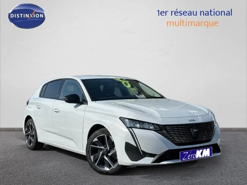 Peugeot 308 blanche vue en 3/4 avant droit avec calandre noire et jantes alliage distinctives.