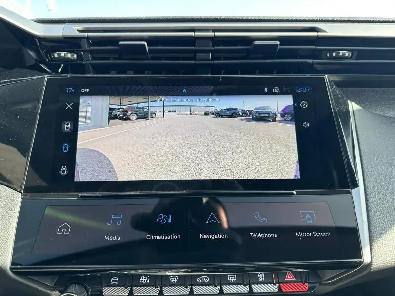 Écran tactile intérieur de la Peugeot 308 bleu montrant la caméra de recul avec vue arrière du parking.