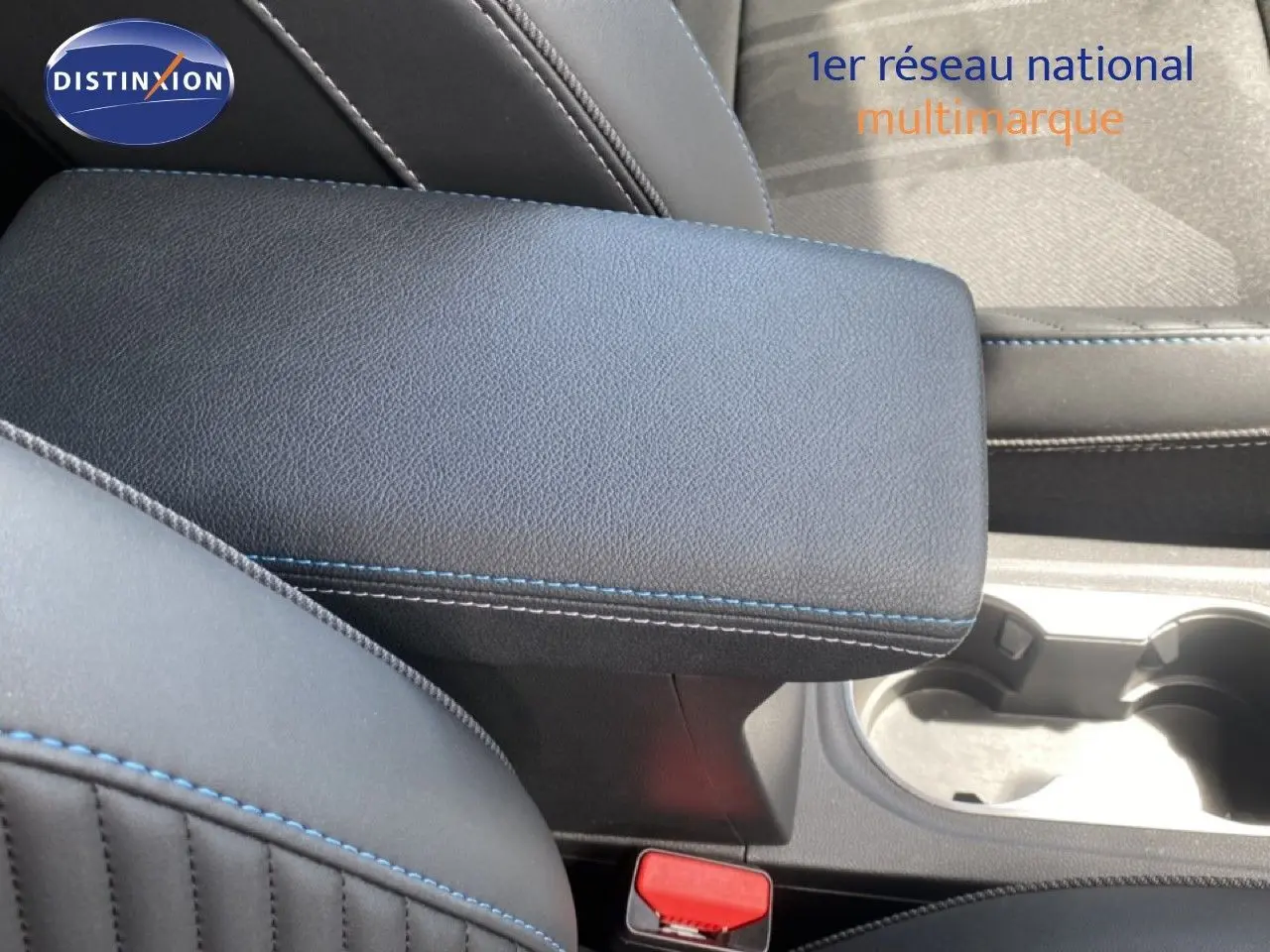 Gros plan sur l'accoudoir central en cuir noir avec surpiqûres bleues dans l'habitacle du Renault Symbioz 2025.