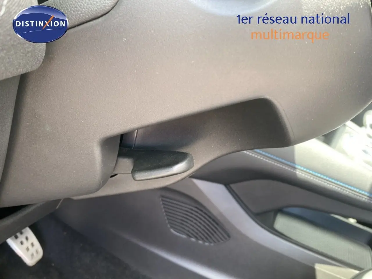 Détail intérieur montrant la commande sous le tableau de bord avec surpiqûres bleues du Renault Symbioz bleu iron metal.