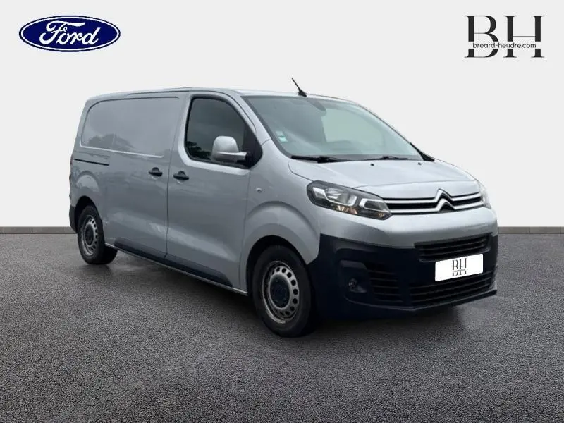 Citroën Jumpy gris aluminium en 3/4 avant droit, fourgon utilitaire avec double portes arrière et pare-chocs noir.