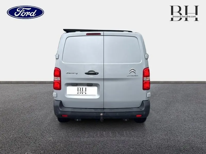 Vue arrière d'un Citroën Jumpy gris aluminium avec portes battantes et feux rouges verticaux.