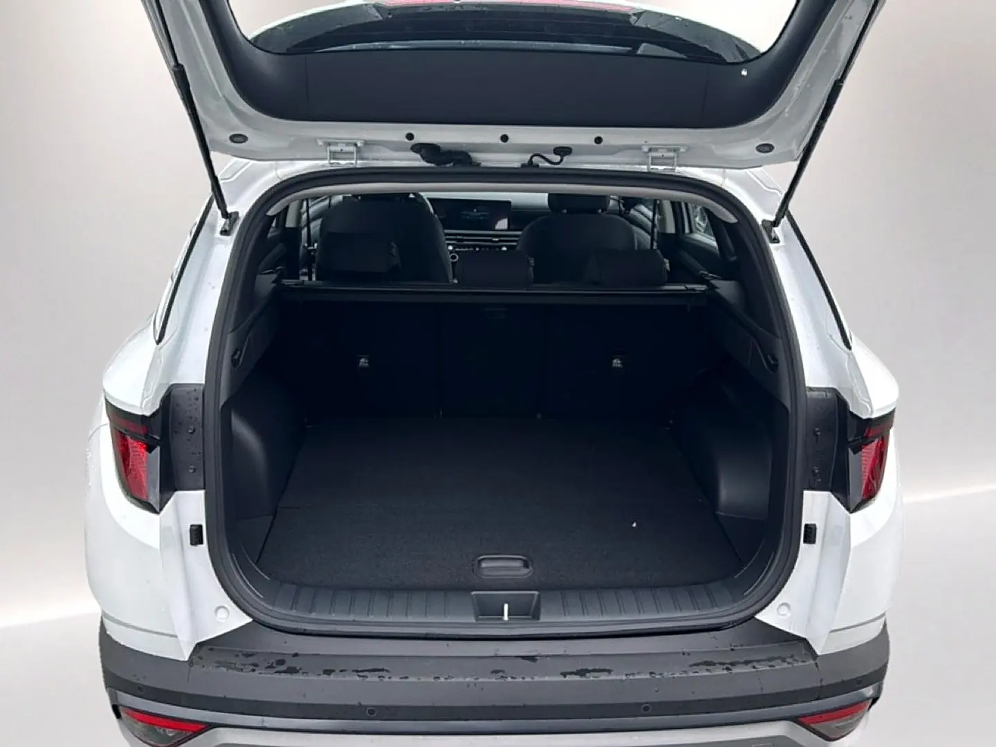Coffre ouvert vu de l'arrière d'un Hyundai Tucson blanc 2026, montrant l'espace de chargement vide.