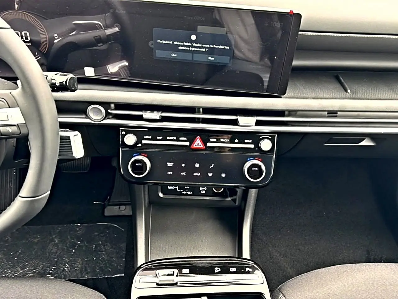 Vue intérieure du tableau de bord du Hyundai Tucson 2026, écran tactile large et commandes climatisation modernes.