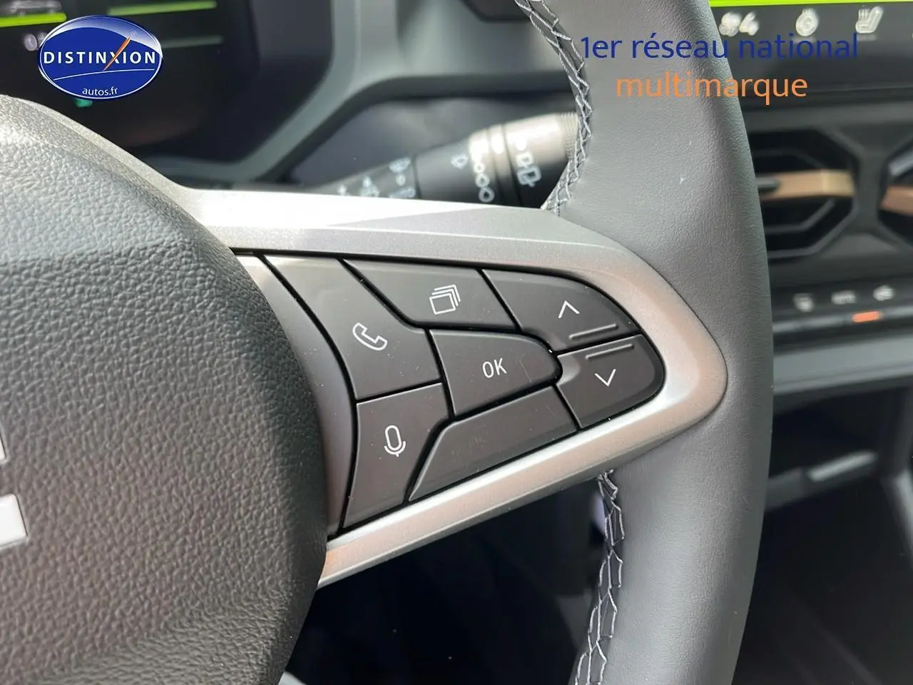 Gros plan sur les commandes multifonctions à droite du volant du Dacia Duster noir 2025, intérieur moderne.