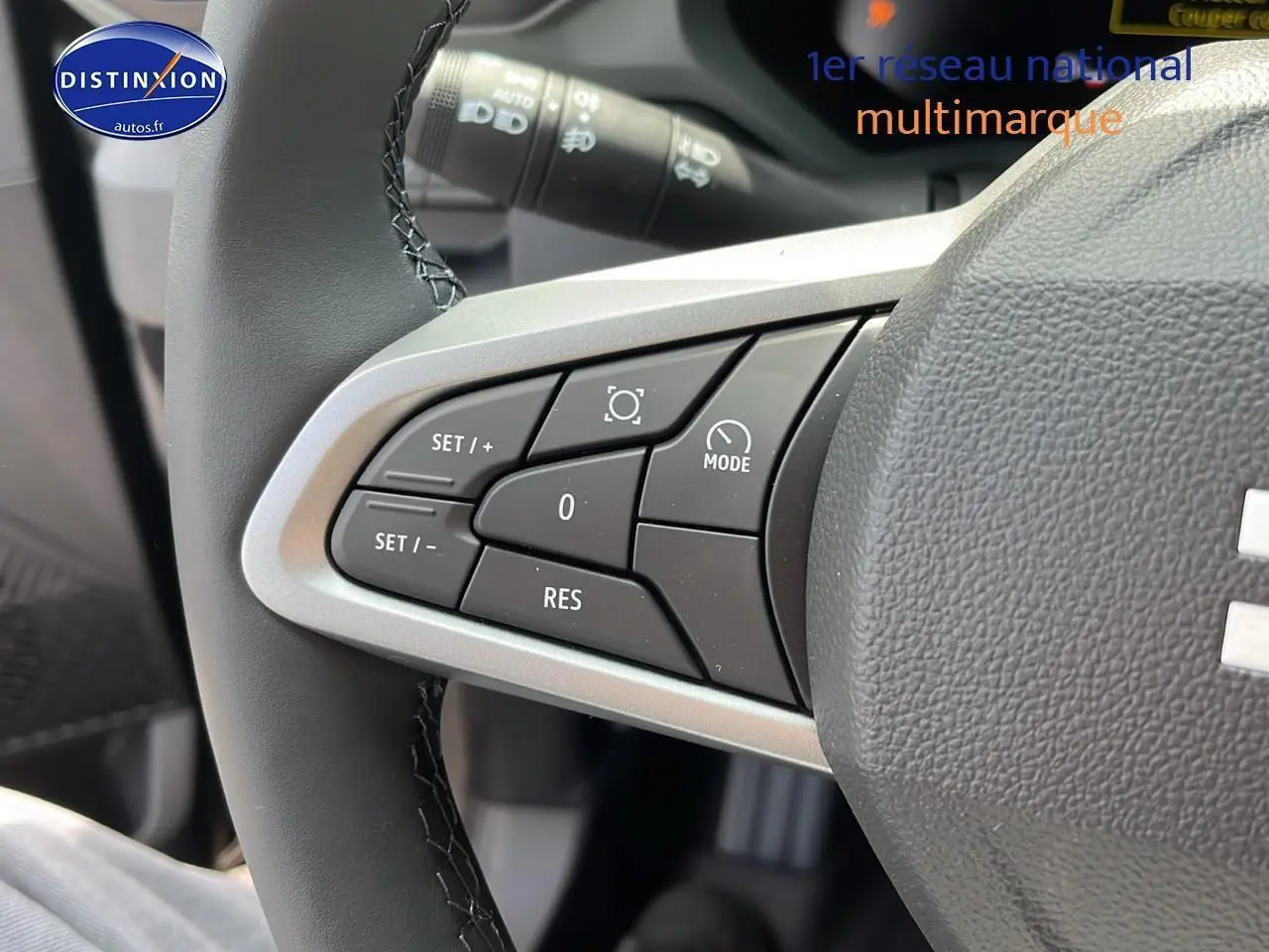Gros plan sur les commandes multifonctions du volant du Dacia Duster noir 2025, côté gauche.