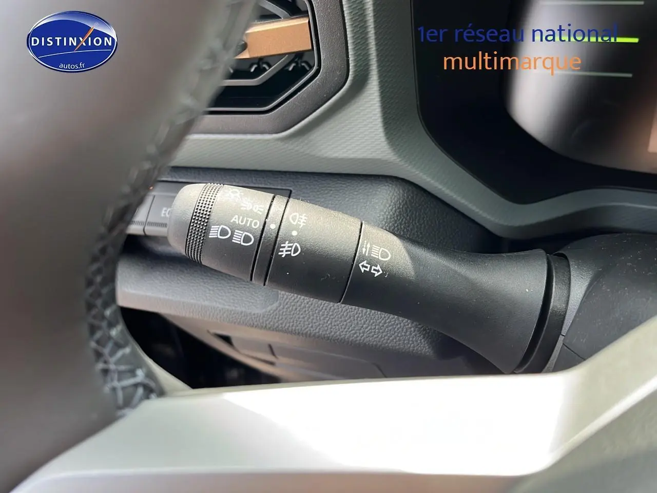 Gros plan sur la commande des phares et clignotants du tableau de bord du Dacia Duster noir 2025.
