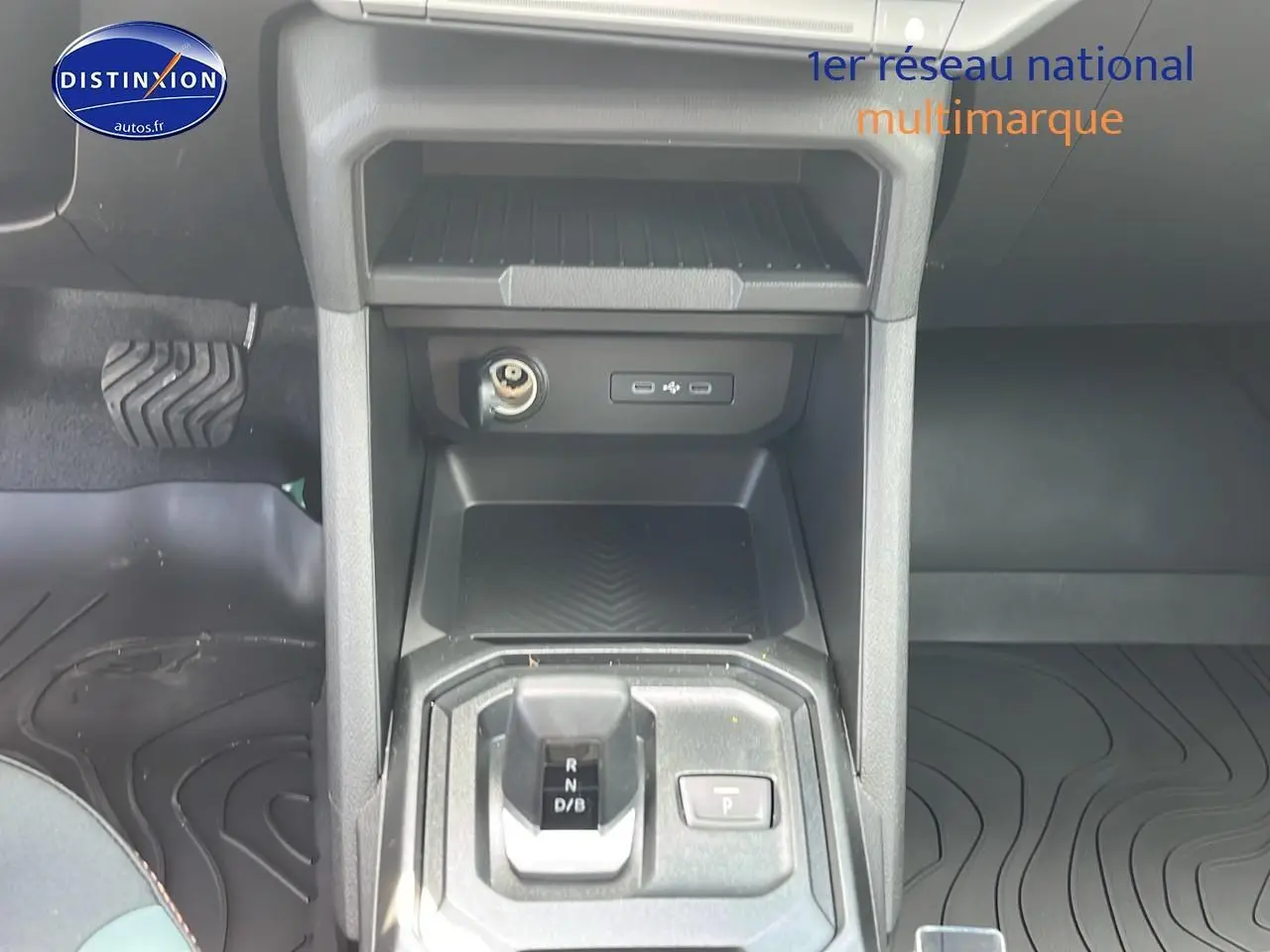 Vue rapprochée de la console centrale du Dacia Duster 2025 noir, mettant en valeur le levier de vitesses et les prises USB.