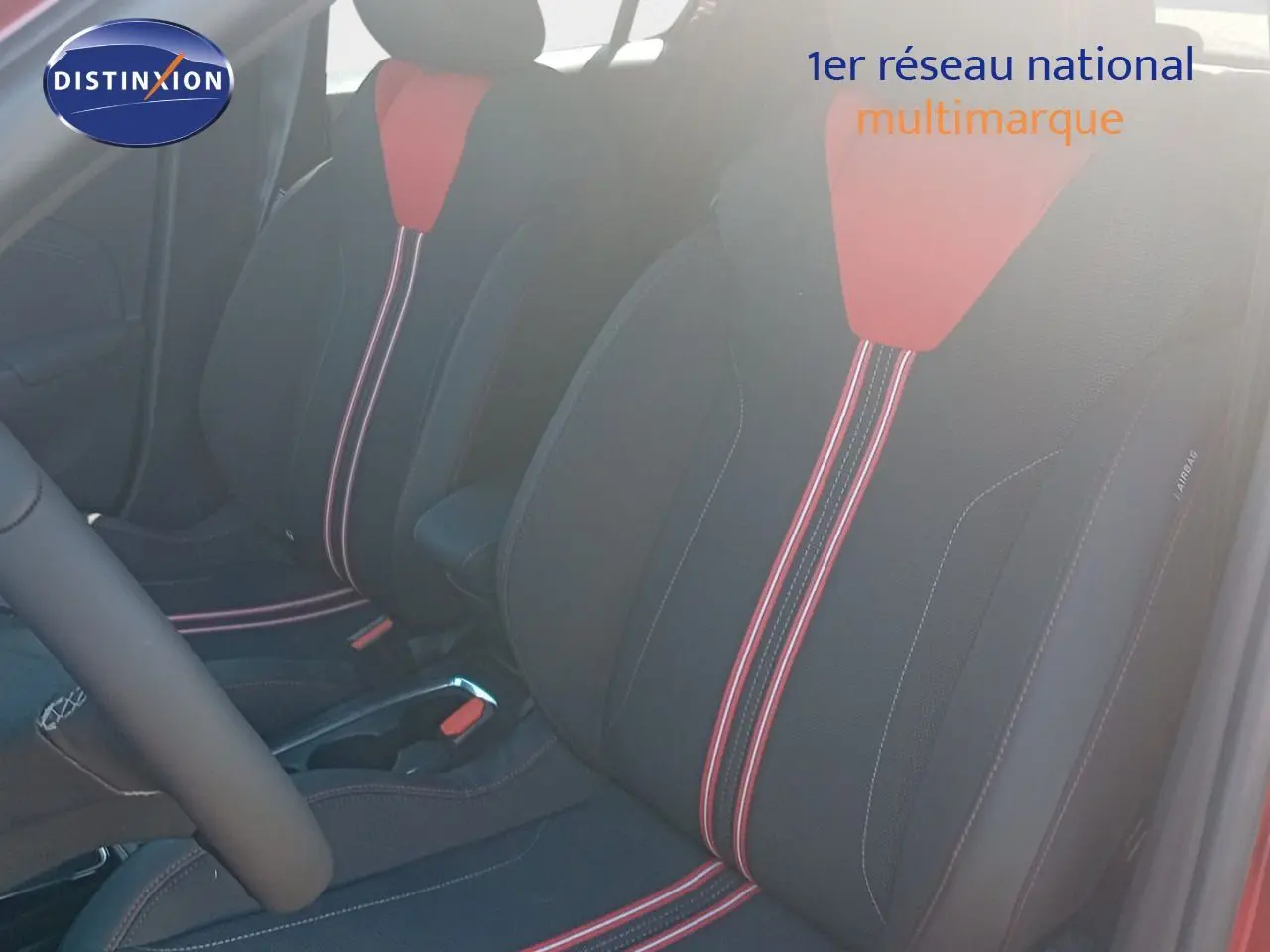 Gros plan sur les sièges avant noirs avec surpiqûres rouges de l'Opel Corsa rouge Kardio métal 2023.