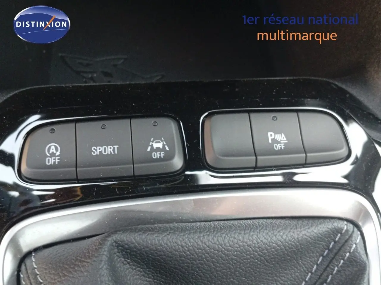 Gros plan sur les commandes de mode sport et assistance au stationnement de l’Opel Corsa rouge Kardio métal toit noir 2023.