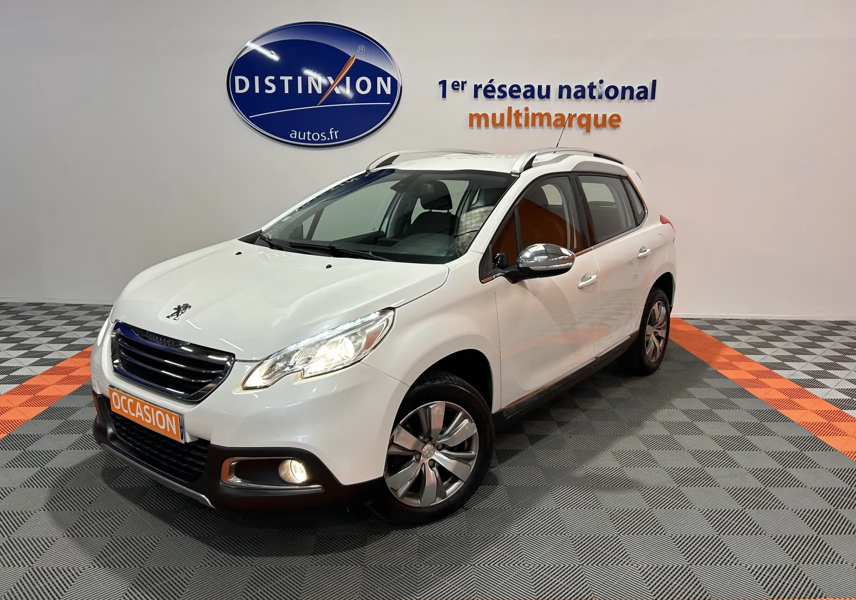Peugeot 2008 blanc vue 3/4 avant droit avec phares et antibrouillards allumés en showroom.