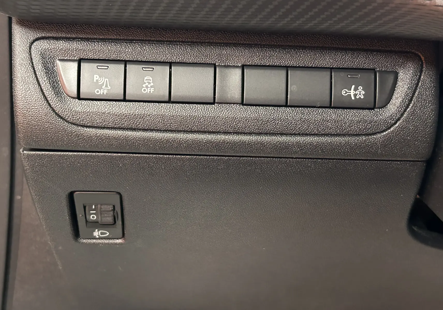 Gros plan sur les boutons de commande du tableau de bord côté conducteur du Peugeot 2008 blanc VTi 82 Allure 2014.