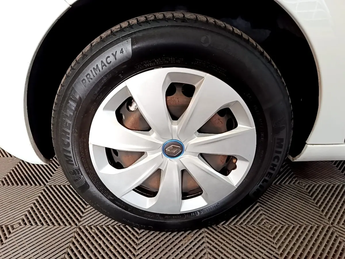 Gros plan sur la roue avant gauche blanche d'une Renault ZOE Business R110 avec jante et logo Renault au centre.