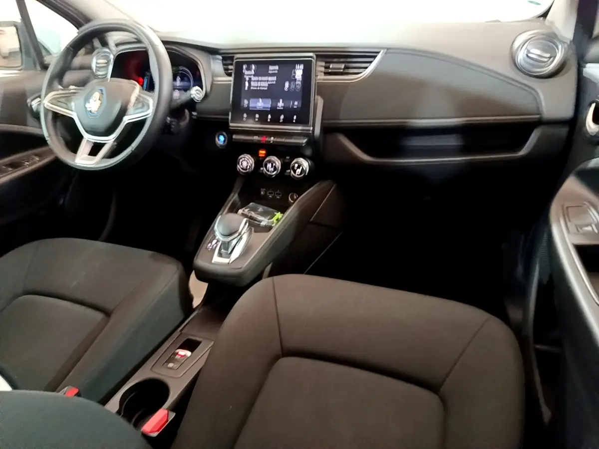 Vue intérieure avant de la Renault ZOE Business R110 2021, tableau de bord noir avec écran tactile central et volant multifonctions.