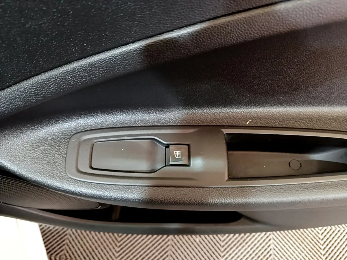 Gros plan sur la commande de lève-vitre côté gauche de la porte intérieure d'une Renault ZOE blanche de 2021.