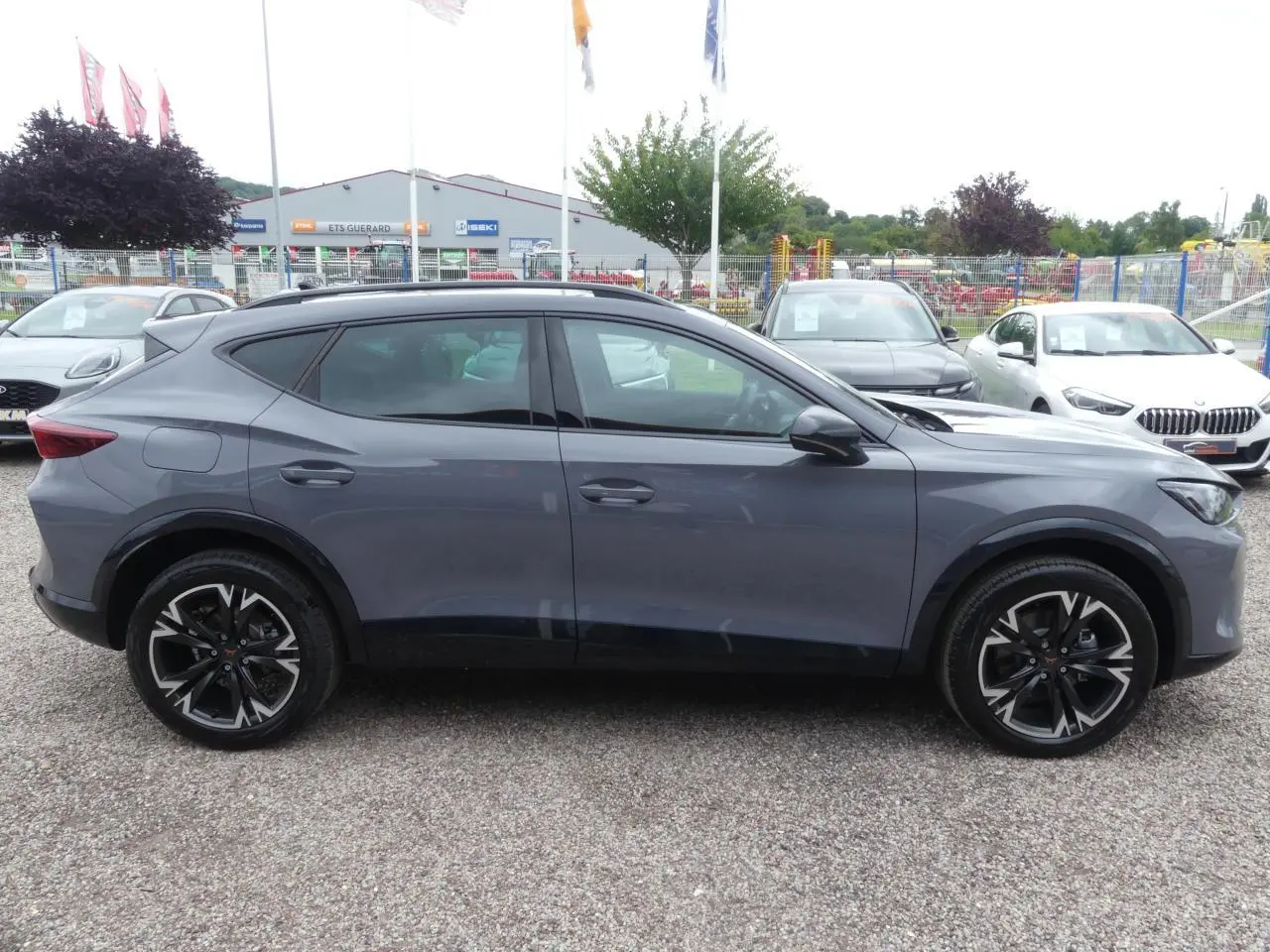 Profil droit du CUPRA Formentor gris Graphène avec jantes alliage noires et coques de rétroviseurs noires contrastantes.