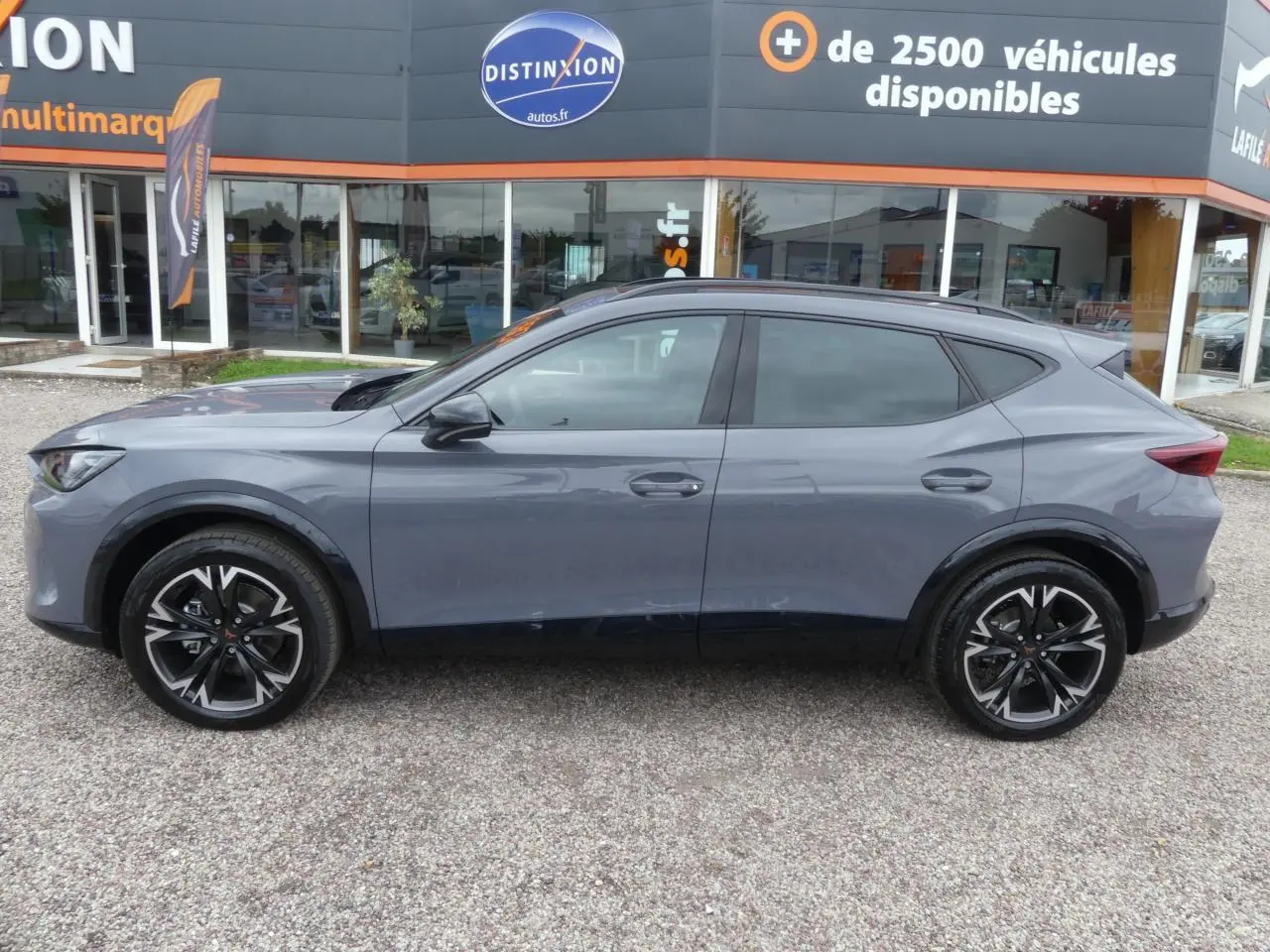 Vue de profil côté gauche d’un CUPRA Formentor gris Graphène avec jantes alliage noires et coques de rétroviseurs noires.