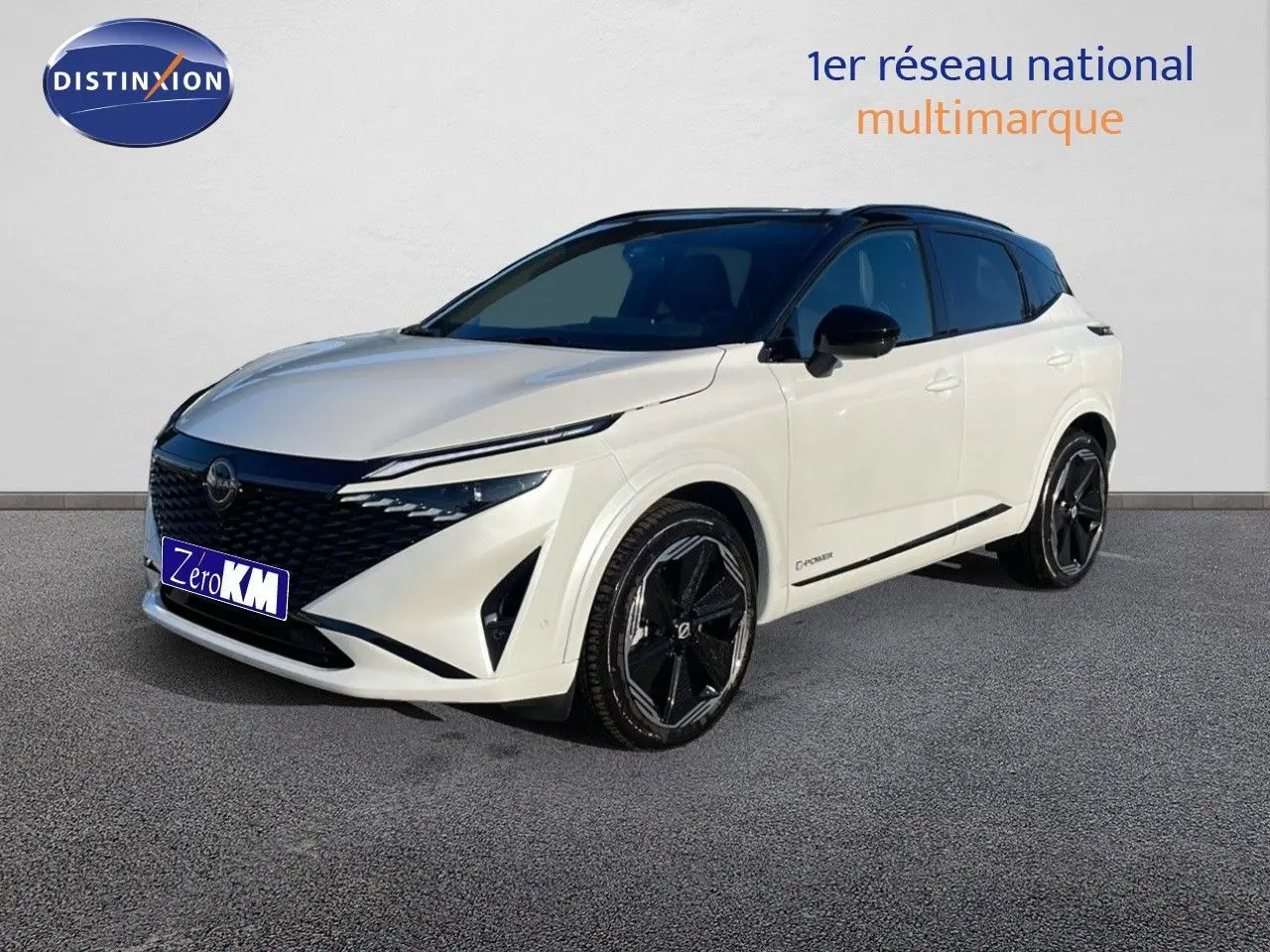 Nissan Qashqai blanc nacré toit noir en 3/4 avant droit, avec jantes noires et calandre imposante.