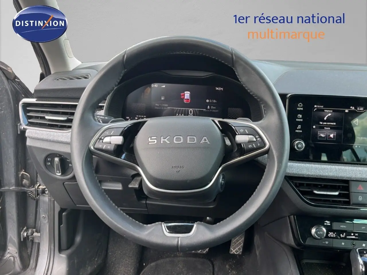 Vue intérieure centrée sur le volant cuir noir et le tableau de bord numérique d'une Skoda Scala gris magnétique 2025.