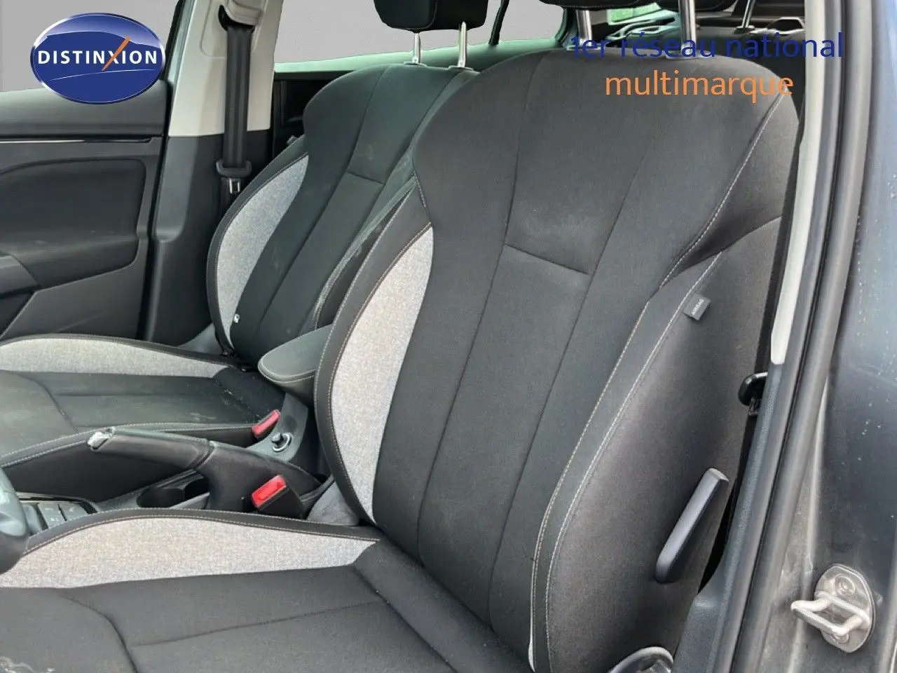 Vue intérieure côté gauche des sièges avant en tissu gris clair et noir d'une Skoda Scala 2025.