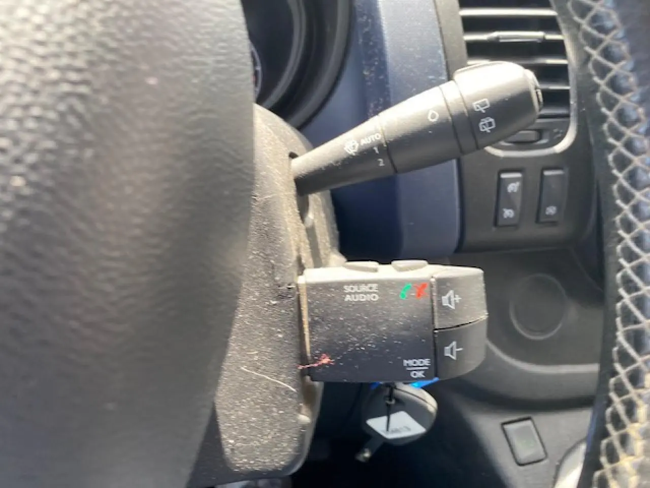 Gros plan sur la commande audio au volant et le commodo d’essuie-glace dans l’habitacle d’un Opel Vivaro blanc 2018.