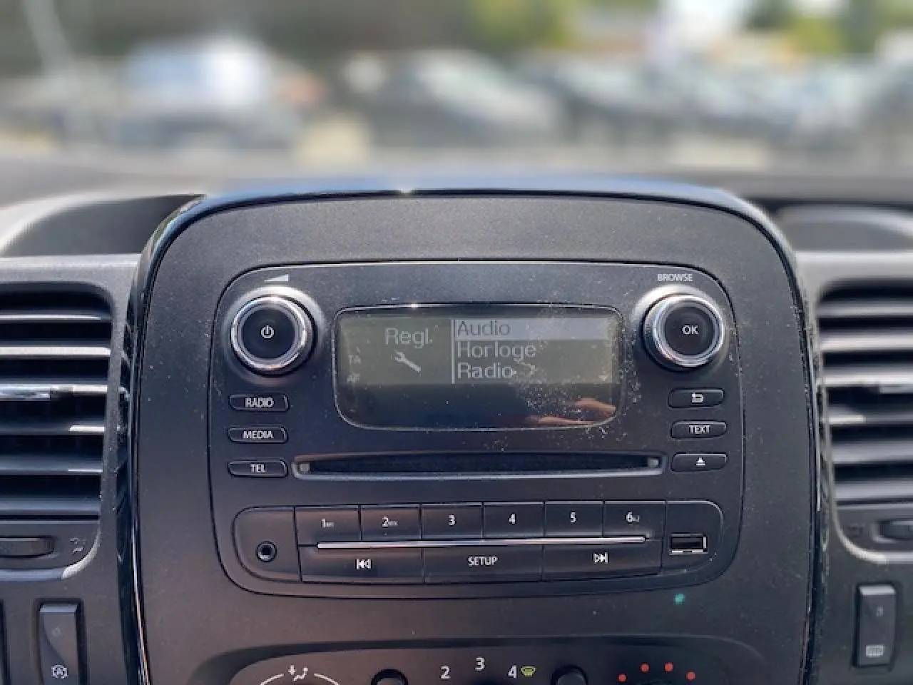 Tableau de bord noir de l'Opel Vivaro 2018 avec écran radio et commandes audio visibles en gros plan.