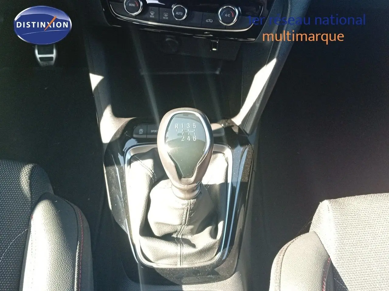 Le levier de vitesse manuel de la Opel Corsa 1.2 Turbo 2023 vu de dessus, entouré de sièges noirs en tissu.