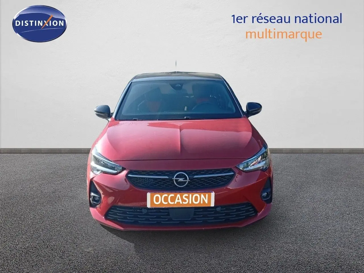 Vue frontale d'une Opel Corsa 2023 rouge Kardio métal avec toit noir, affichant sa calandre et phares LED.