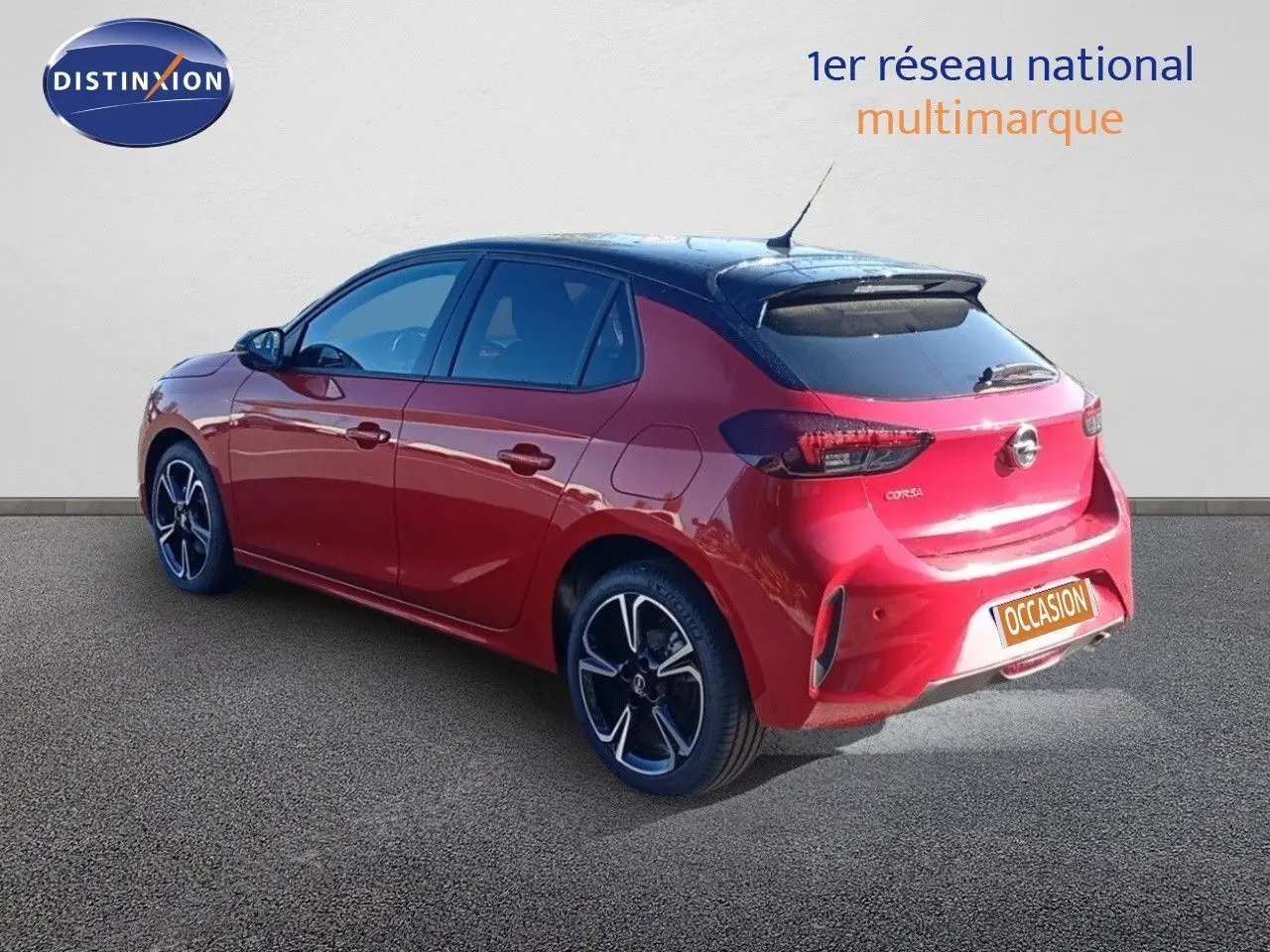 Vue 3/4 arrière droite d'une Opel Corsa rouge Kardio métal avec toit noir et jantes alliage noires.