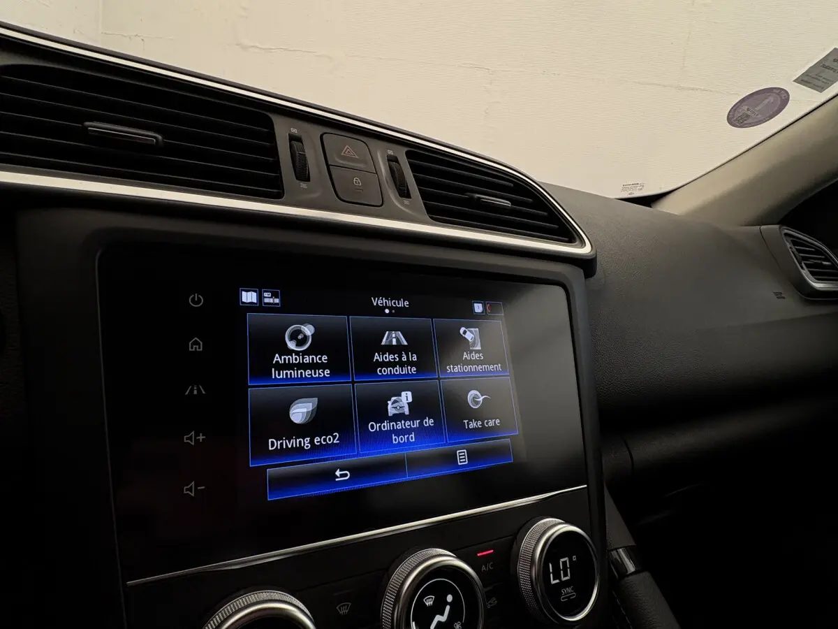 Vue intérieure du tableau de bord du Renault Kadjar Intens 2019, écran tactile central affichant les aides à la conduite.