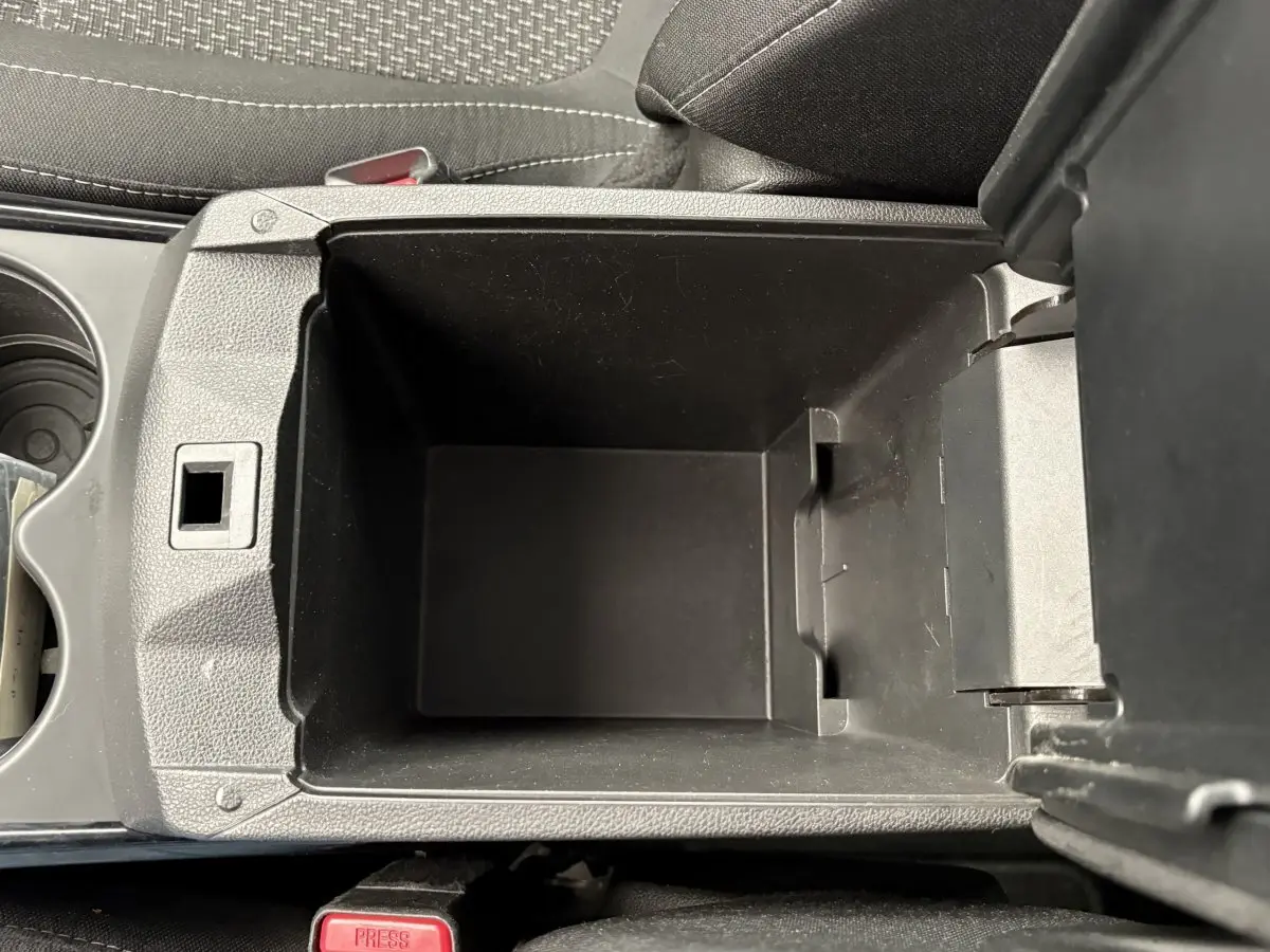 Vue plongeante sur le rangement central noir ouvert de la Renault Kadjar Intens gris foncé, intérieur tissu gris.