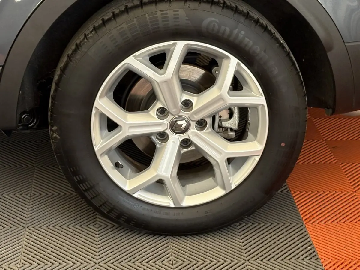 Gros plan sur la roue avant droite du Renault Kadjar gris foncé, mettant en valeur la jante alliage au design moderne.