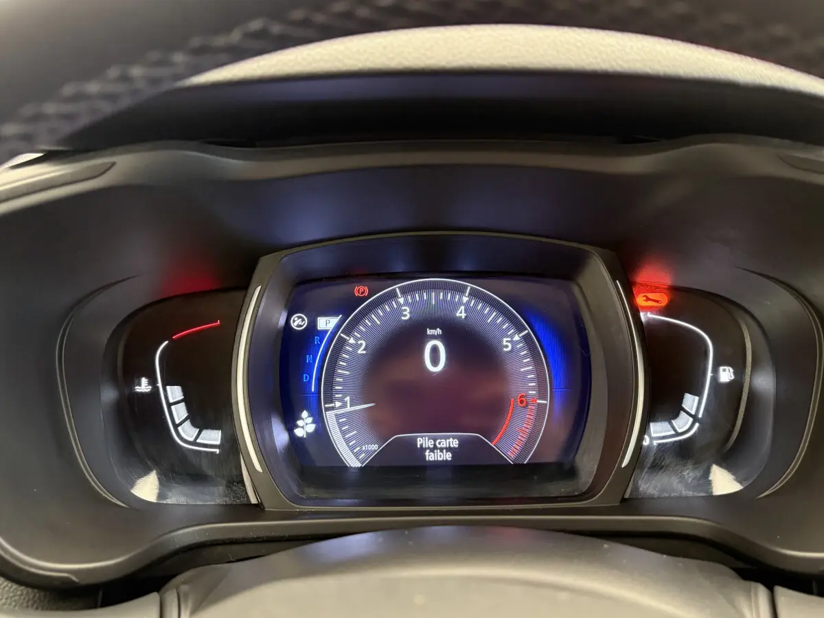 Vue rapprochée du tableau de bord numérique du Renault Kadjar 2019 affichant le compteur et un message "Pile carte faible".