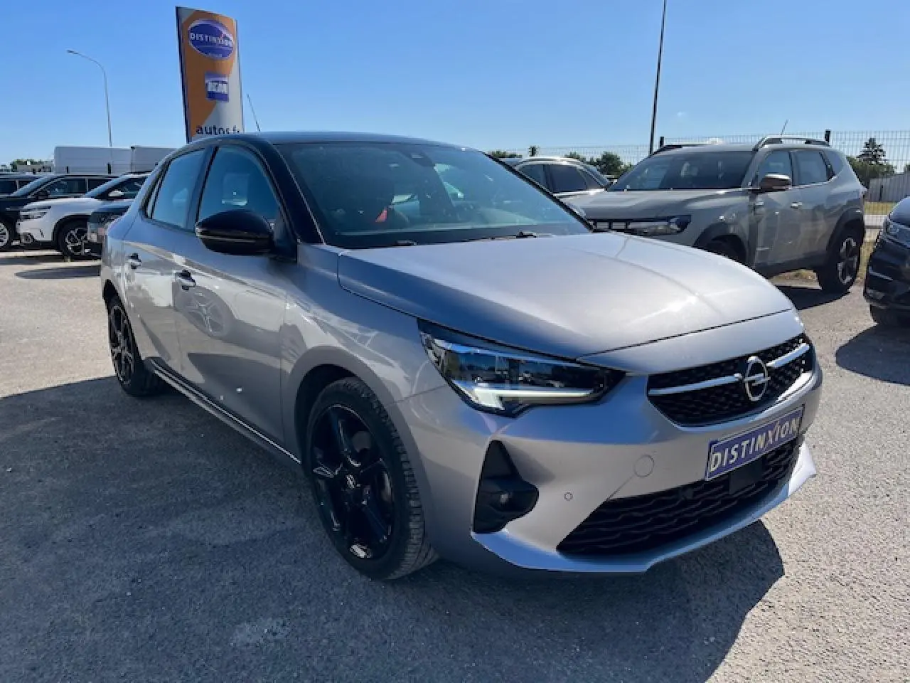 Opel Corsa 1.2i Turbo gris et toit noir, vue 3/4 avant droit, avec jantes noires et calandre distinctive.