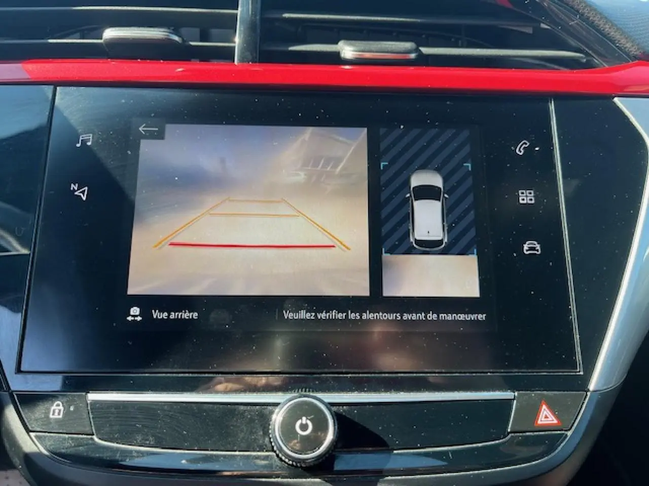 Écran central de l’Opel Corsa gris/noir montrant la caméra de recul à 180° et l’aide au stationnement arrière.