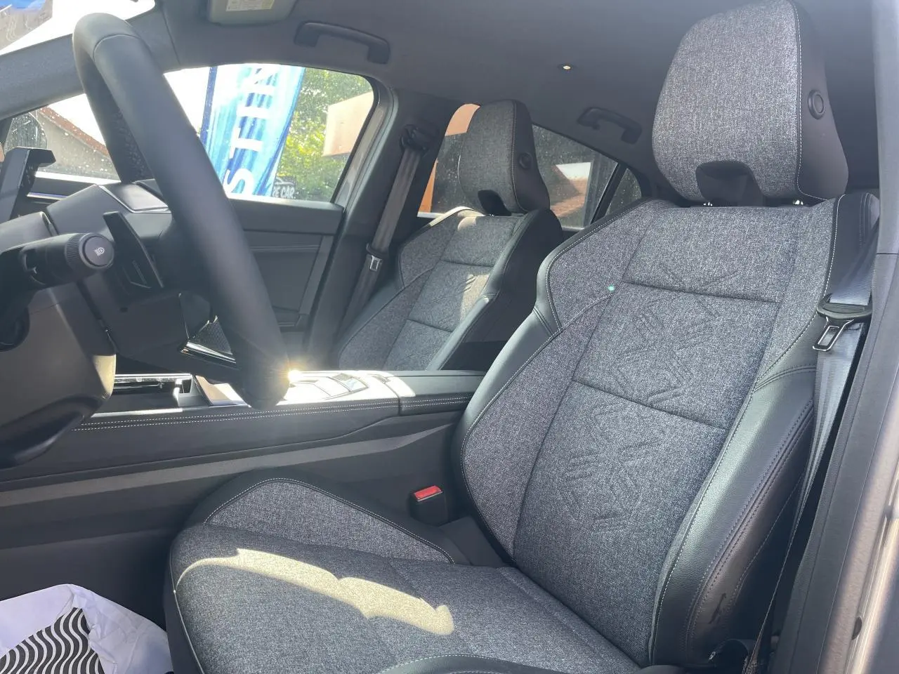 Intérieur côté conducteur de Renault Rafale 2025, sièges sport gris textile avec surpiqûres argent et volant textile refined.