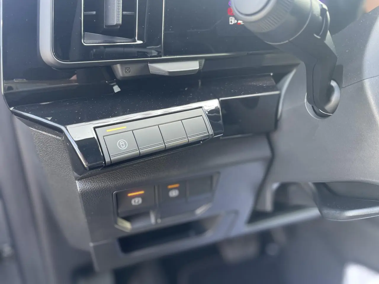 Détail du tableau de bord noir brillant côté gauche avec commandes électroniques du Renault Rafale hybride 2025.