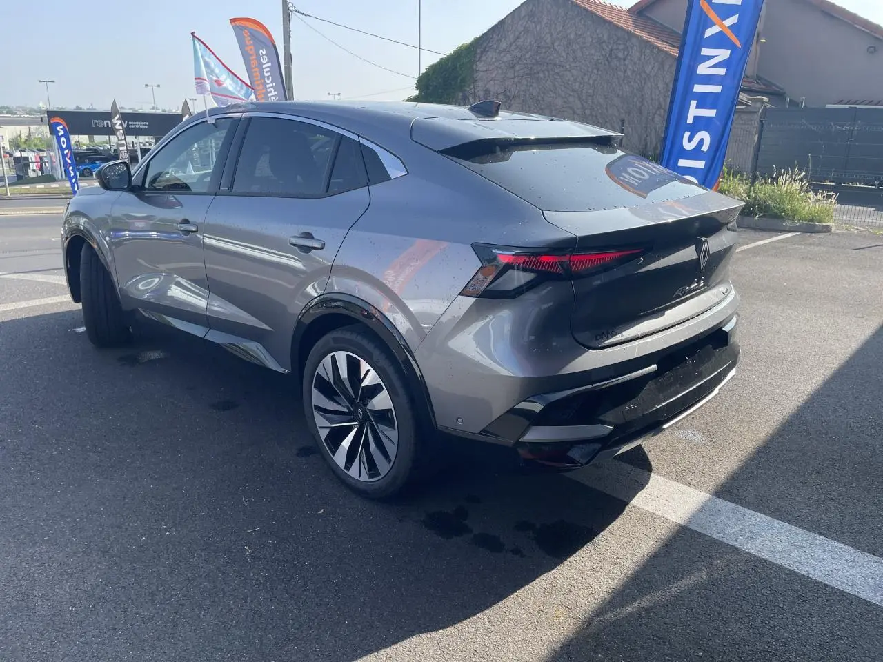 Vue 3/4 arrière droite du Renault Rafale gris à toit noir, soulignant ses feux arrière LED et jantes alliage 20 pouces.