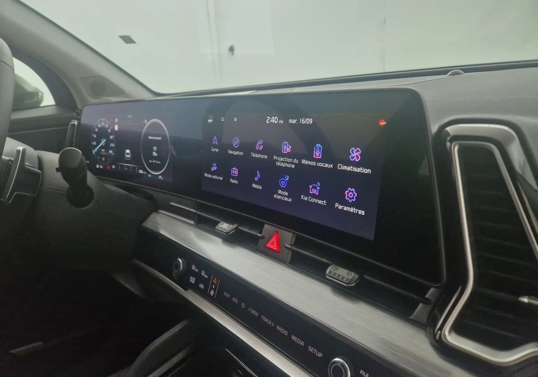 Vue rapprochée du tableau de bord digital 12,3'' du Kia Sportage gris Sirius 2025 avec écran tactile et commandes intégrées.