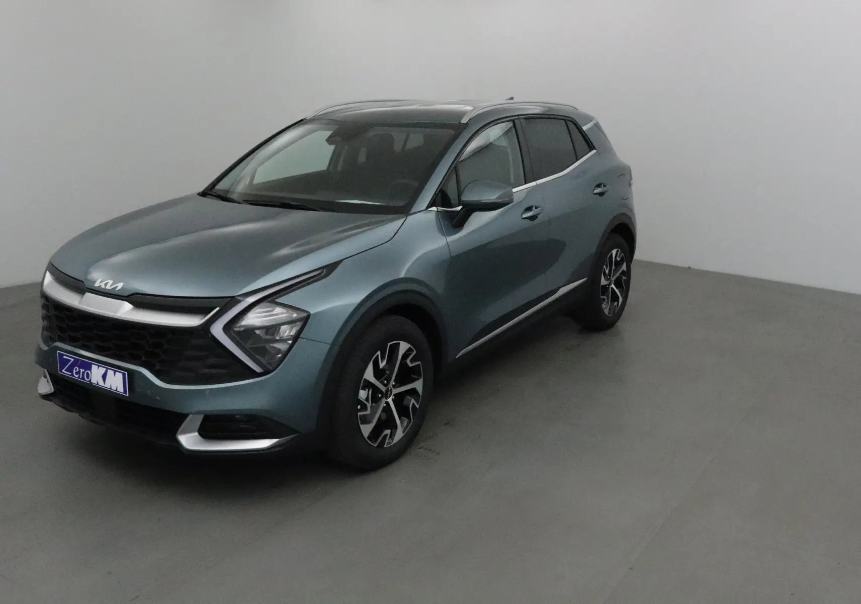 KIA SPORTAGE gris Sirius vu en 3/4 avant droit, avec calandre noire et jantes alliage noires et argentées.