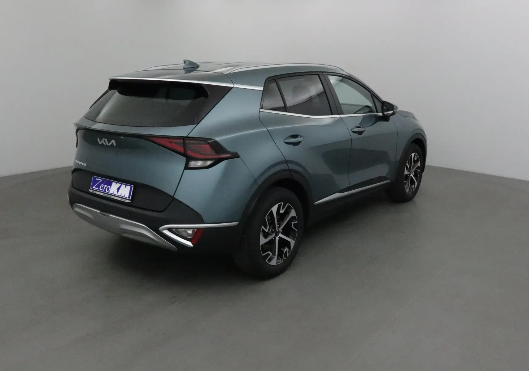 Vue 3/4 arrière droite du Kia Sportage gris Sirius 2025 avec jantes alliage et feux LED distinctifs.