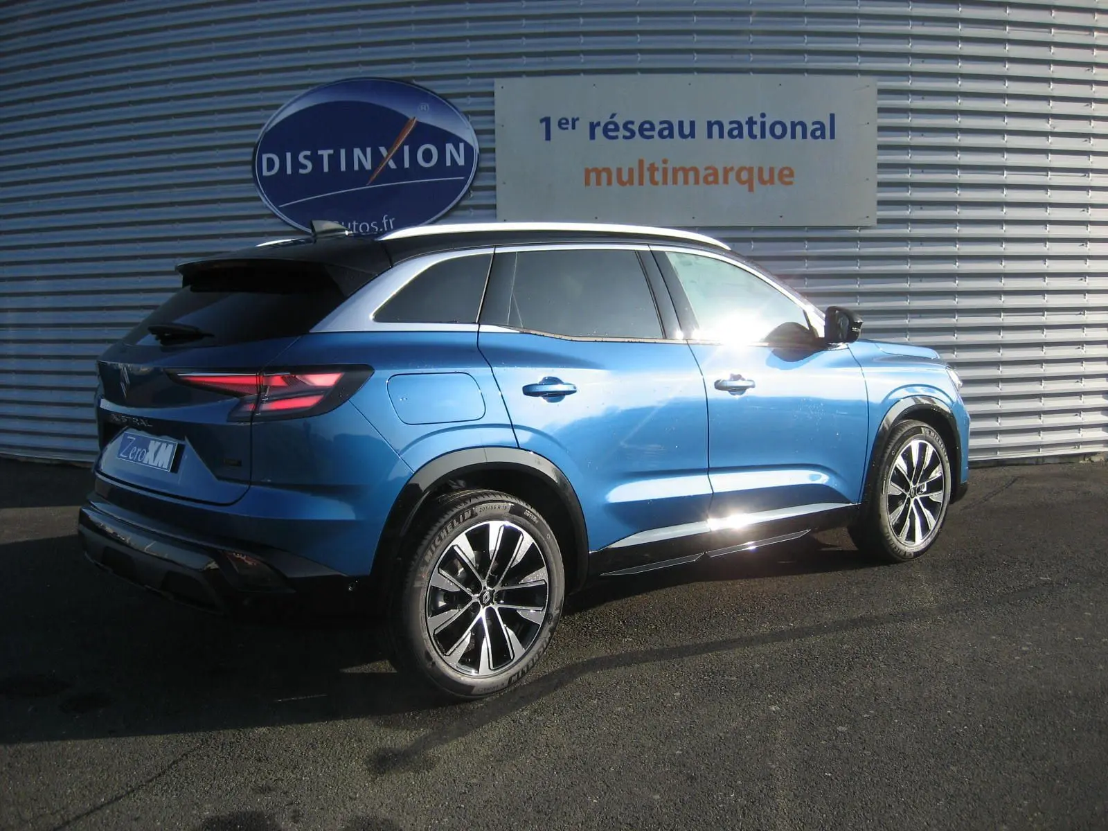 Vue 3/4 arrière droite du Renault Austral 2025 bleu outremer avec toit noir, soulignant ses jantes et lignes dynamiques.