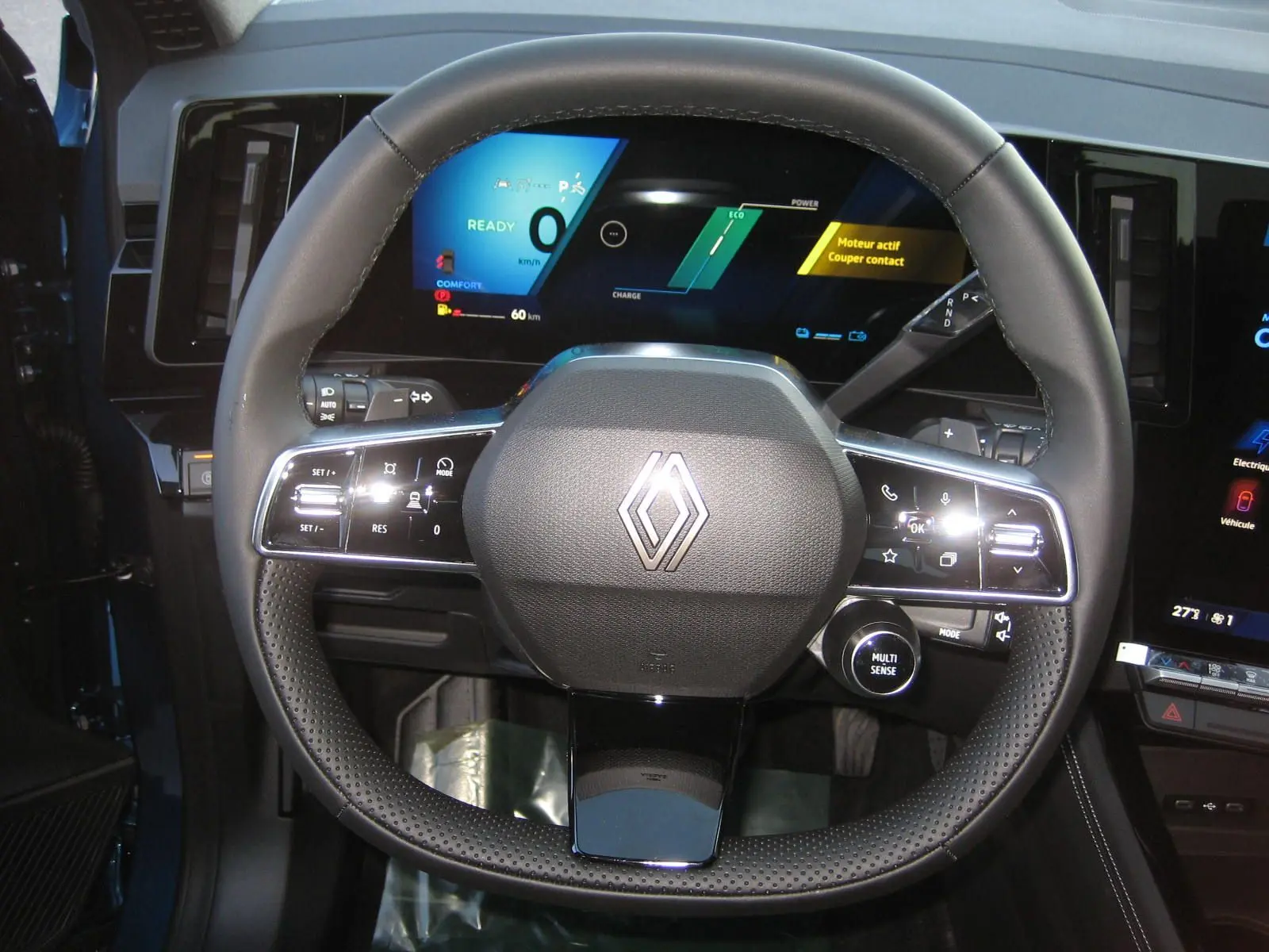 Vue rapprochée du volant multifonction noir du Renault Austral 2025 avec tableau de bord numérique allumé.