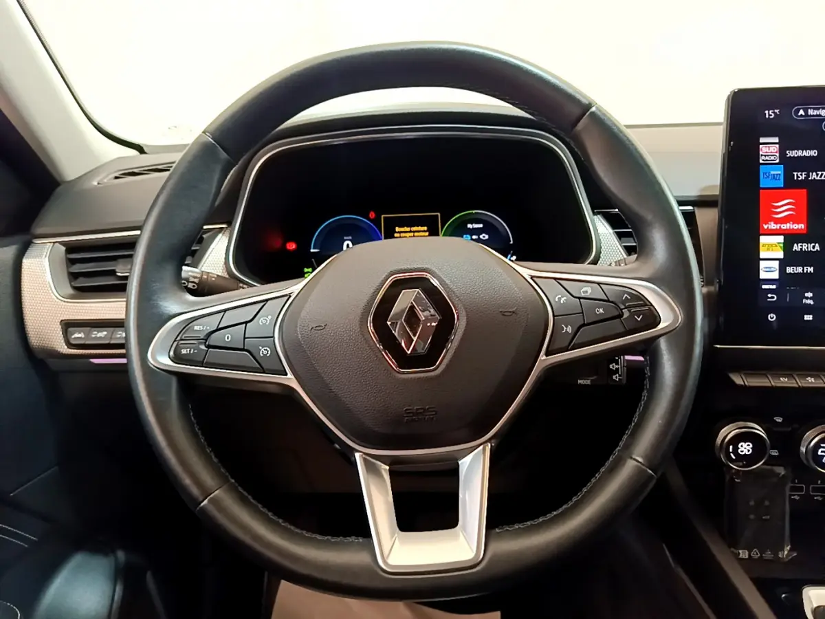 Vue rapprochée du volant cuir noir de la Renault Arkana Techno E-Tech 2023 avec tableau de bord numérique et écran tactile.