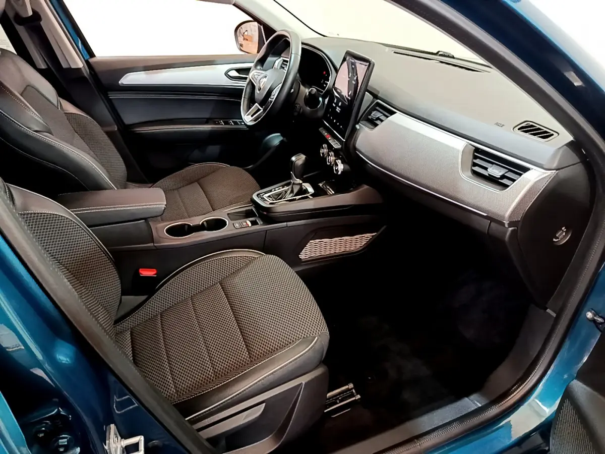 Intérieur avant droit du Renault Arkana bleu 2023, sièges tissu gris, tableau de bord avec écran tactile vertical.