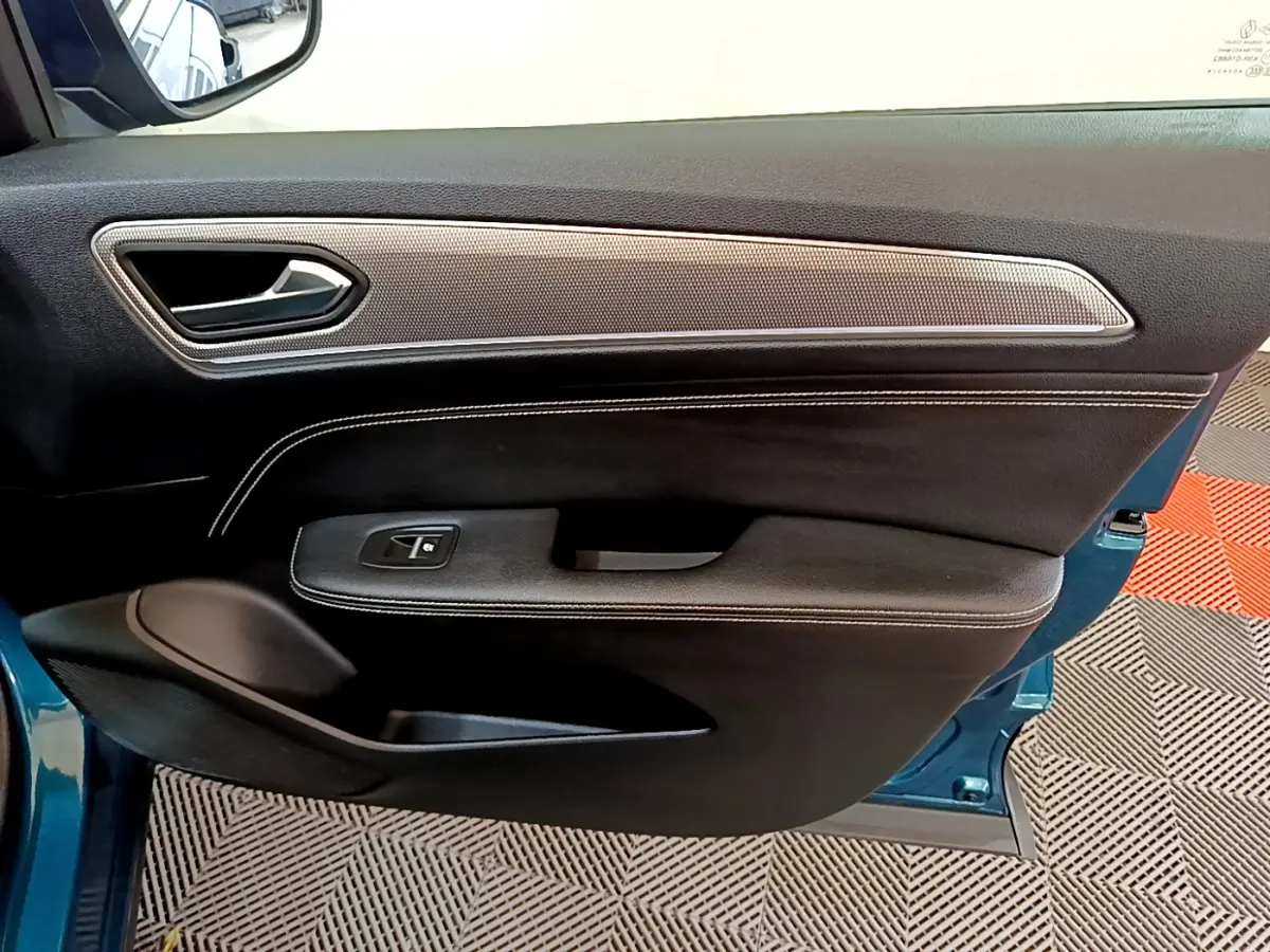 Intérieur de la porte avant gauche bleu Renault Arkana 2023, avec garniture noire et insert argenté texturé.
