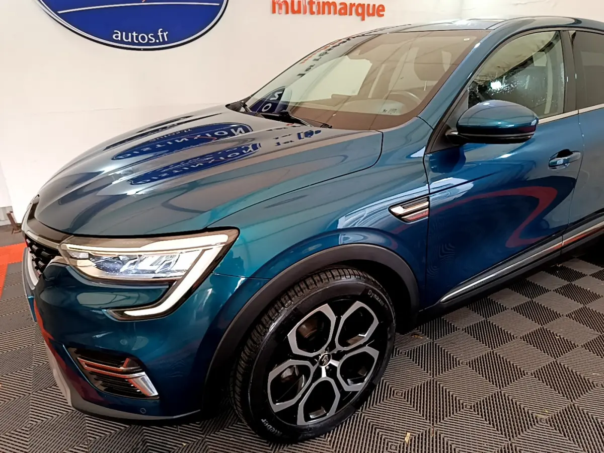 Vue 3/4 avant droit du Renault Arkana bleu, mettant en valeur ses phares LED et ses jantes alliage distinctives.