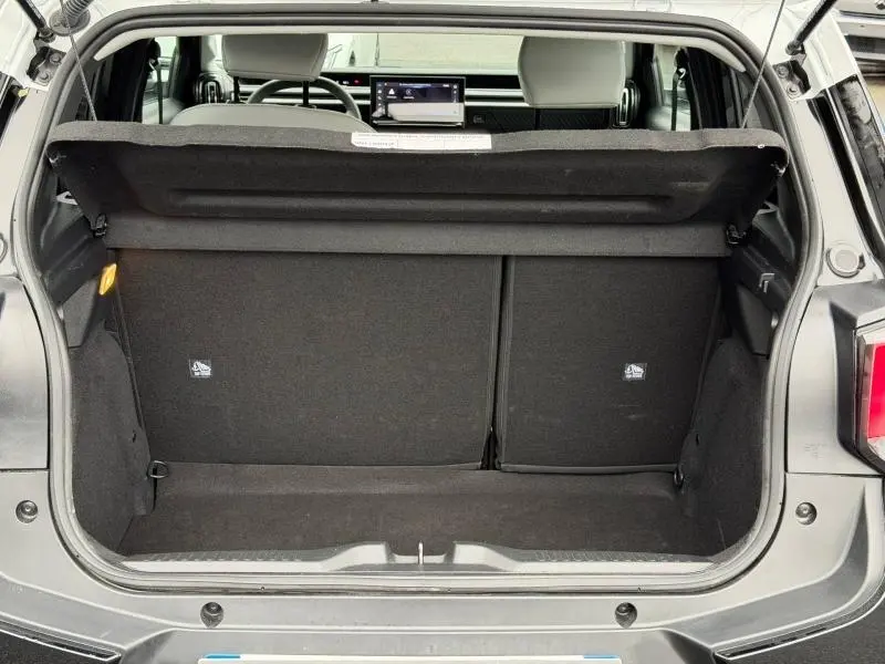 Coffre ouvert vu de l'arrière d'une Citroën C3 noire Perla Nera 2025 avec banquette arrière et tablette tactile visible.